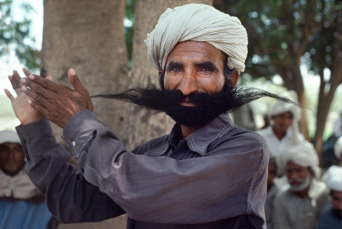 01726_17, Balochistan, Pakistan, 05/1981, PAKISTAN-10059NF. A man in a turban forming his mustache. retouched_Sonny Fabbri 03/04/2015