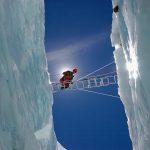 Man crossing crevasse on Mount Everest, Nepal